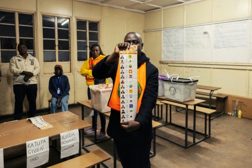 Un responsable de bureau de vote tient un bulletin marqué pendant le dépouillement à l'école primaire Woodlands de Lusaka, en Zambie, le 13 août 2026 — GIANLUIGI GUERCIA / AFP