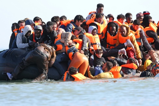 Des migrants montent à bord d'une embarcation de passeurs pour tenter de traverser la Manche au large de la plage de Gravelines, dans le nord de la France, le 29 juillet 2026 — Francois LO PRESTI / AFP