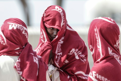 Des migrants attendent après avoir débarqué d'un navire après leur sauvetage en mer alors que leur embarcation avait pris feu lors d'une tentative de traversée de la Manche, au port de commerce de Boulogne-sur-Mer, le 4 août 2026 — Sameer AL-DOUMY / AFP