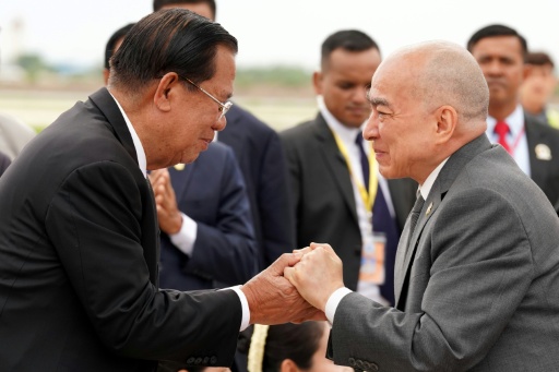 Photo fournie et diffusée par l’Agence Kampuchea Press (AKP) le 3 juillet 2026 montrant le roi du Cambodge Norodom Sihamoni (à droite) salué par l'ancien dirigeant cambodgien Hun Sen (à gauche) à son arrivée à l’aéroport international près de Phnom Penh