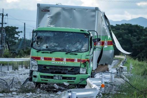 Un camion endommagé est laissé sur une route jonchée de débris à la suite d'une explosion survenue au centre commercial Aeon Mall à Kumamoto, à Kashima, dans le sud du Japon, le 29 juillet 2026, après qu'un tremblement de terre a frappé la région — Yuichi YAMAZAKI / AFP