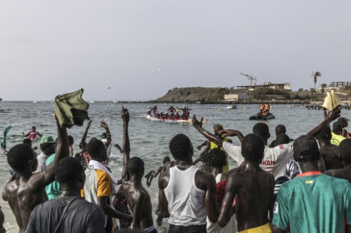 Des spectateurs félicitent des compétiteurs victorieux lors des courses de pirogues annuelles au large de l'île de Ngor, à Dakar