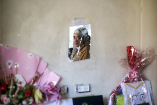 La estudiante palestina Saba Rabah se observa en un espejo quebrado en el campo de refugiados palestinos de Maghazi, el 26 de junio de 2026 — Eyad Baba / AFP