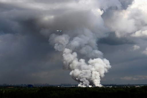 Un avión de pasajeros sobrevuela el humo del almacén del gigante del comercio electrónico ruso atacado con drones por Ucrania en la ciudad de San Petersburgo el 24 de julio de 2026 — Stringer / AFP