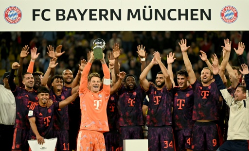 El arquero Manuel Neuer levanta el trofeo de la Supercopa de Alemania ganado por el Bayern Munich tras ganar 2-1 en el campo del Borussia Dortmund, el 22 de agosto de 2026 — INA FASSBENDER / AFP