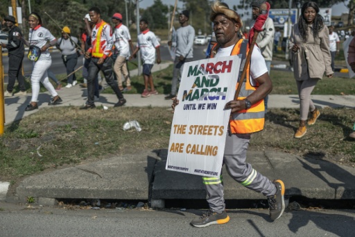 Un manifestant du mouvement March and March brandit une banderole lors d’une manifestation à Pinetown, au sud de Durban, le 16 juillet 2026 — RAJESH JANTILAL / AFP
