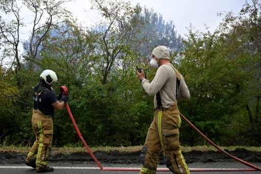 Des pompiers manœuvrent des lances pour lutter contre un incendie dans la réserve naturelle des Hautes Fagnes près de Waimes, dans l'est de la Belgique, le 17 août 2026 — JOHN THYS / AFP