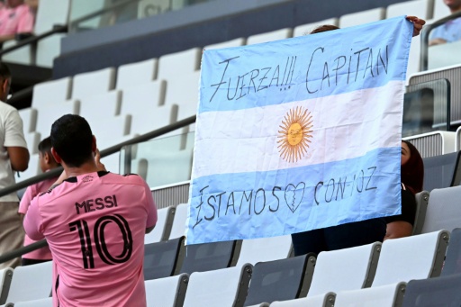 Un supporteur de l'Inter Miami tient un drapeau argentin portant un message de soutien pour Lionel Messi à la suite de la mort de son père, le 8 août 2026 à Miami — CHANDAN KHANNA / AFP