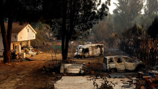 Des carcasses de voitures calcinées dans une propriété après un incendie de forêt à Pelayos de la Presa, à environ 65 km à l'ouest de Madrid, le 26 juillet 2026 — Oscar DEL POZO / AFP