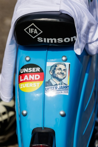 A Simson moped with an AfD sticker showing Siegmund's likeness and another that reads 'Our Country First'