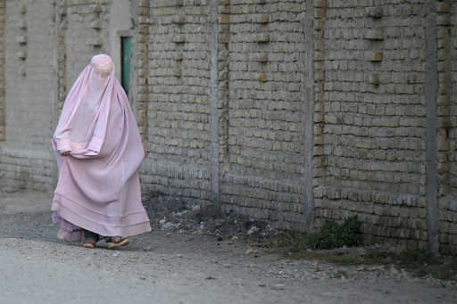 An Afghan burqa-clad woman walks along a street in the Dand district of Afghanistan's Kandahar on August 11, 2026. — Sanaullah SEIAM / AFP