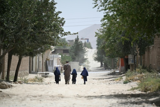 Un padre lleva a sus hijas a una escuela primaria en Kabul — Isabelle WESSELINGH / AFP
