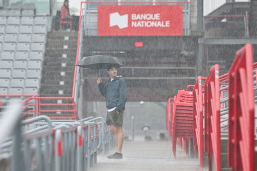 A spectator looks on during a rain delay at the ATP Montreal Masters — Minas Panagiotakis