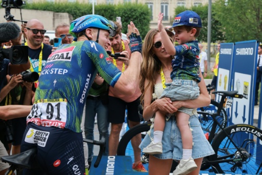 Le Belge Tim Merlier célèbre sa victoire sur la 12e étape du Tour de France avec son fils Jules et sa compagne, Cameron Vandenbroucke, le 16 juillet 2026 à Chalon-sur-Saône — Stephanie Lecocq / AFP