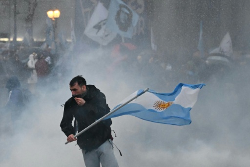 Manifestante em meio ao gás lacrimogêneo, em frente ao Congresso argentino, em Buenos Aires — Luis ROBAYO / AFP