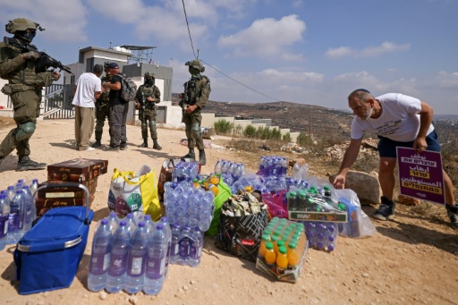 جنود إسرائيليون يقفون أمام منزل فلسطيني يحاصره مستوطنون في قرية قصرة، في شمال الضفة الغربية المحتلة في 14 آب/أغسطس 2026 — جعفر اشتية