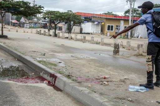 Un homme montre une mare de sang, le 29 octobre 2025,  dans une rue de Dar es Salaam, capitale économique de la Tanzanie