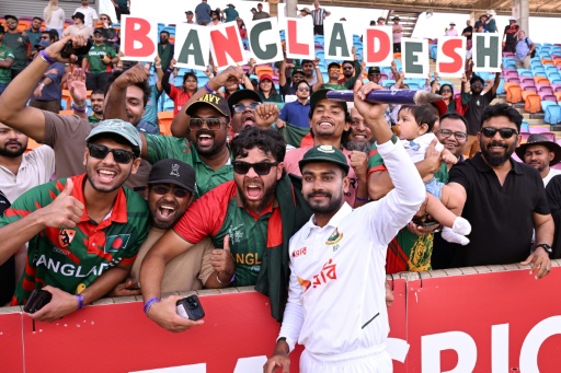 Bangladesh player Mehidy Hasan Miraz poses with fans after victory against Australia — William WEST / AFP
