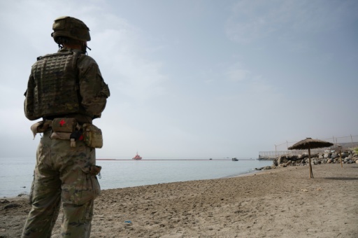 Un militaire espagnol en faction sur une plage alors que la Garde civile espagnole déploie en mer une barrière pneumatique pour empêcher de nouvelles  entrées illégales depuis le Maroc dans l'enclave espagnole de Ceuta, sur la côte nord du Maroc, le 1er août 2026 — JORGE GUERRERO / AFP