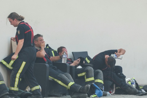 Des pompiers se reposent avec des bouteilles d'eau pendant une pause au cours des opérations de lutte contre un incendie de forêt près de Lanton, dans le sud-ouest de la France, le 29 juillet 2026 — Alain JOCARD / AFP