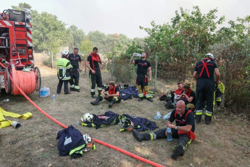 Des pompiers se reposent avec des bouteilles d'eau pendant une pause au cours des opérations de lutte contre un incendie de forêt près de Lanton, dans le sud-ouest de la France, le 29 juillet 2026 — ALAIN JOCARD / AFP