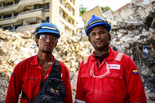Les secouristes bénévoles Ender Liendo (g.) et Frank Viloria posent pour une photo lors d'opérations d'inspection dans une zone touchée par le tremblement de terre du 24 juin à Catia La Mar, au Venezuela, le 4 août 2026 — Maxwell BRICENO / AFP