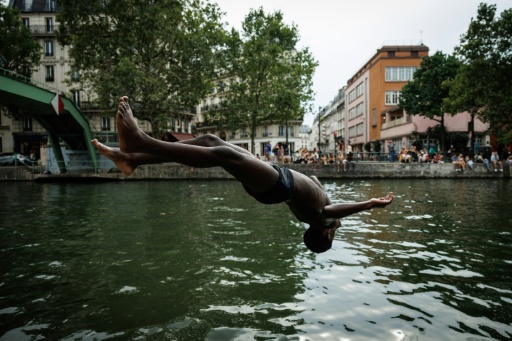 Un joven salta al Canal Saint-Martin, en París, el 3 de agosto de 2026 — Simon WOHLFAHRT / AFP