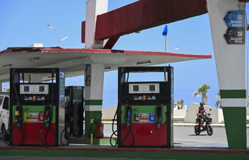 A man rides past an empty gas station in Havana — YAMIL LAGE / AFP