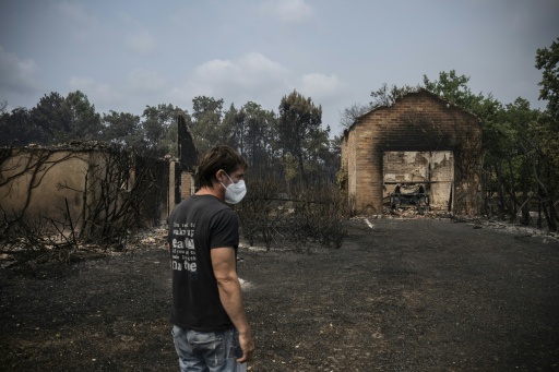 Un pompier éteint avec une pelle les débris d'un incendie qui couvent à Marcheprime, à l'ouest de Bordeaux, le 26 juillet 2026 — Alain JOCARD / AFP