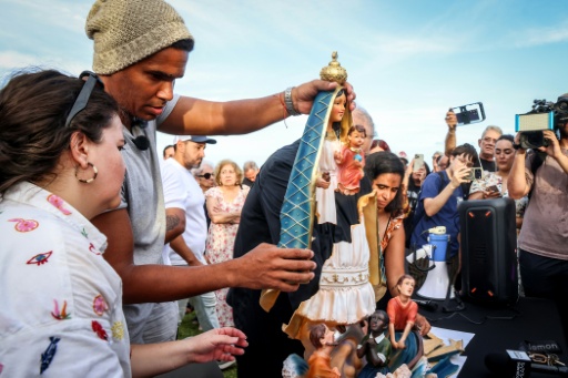 Cuban dissident Luis Manuel Otero Alcantara places a statue from Havana at the National Shrine of Our Lady of Charity in Miami, where he spoke to the Cuban exile community — Giorgio Viera / AFP