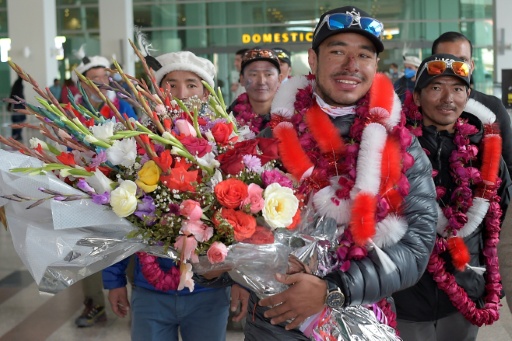 Nepal's climber Nirmal Purja (2R) walks upon his arrival along with his team at the airport after becoming the firsts to summit Pakistan's K2 mountain in winter, in Islamabad on January 21, 2021 — Farooq NAEEM / AFP