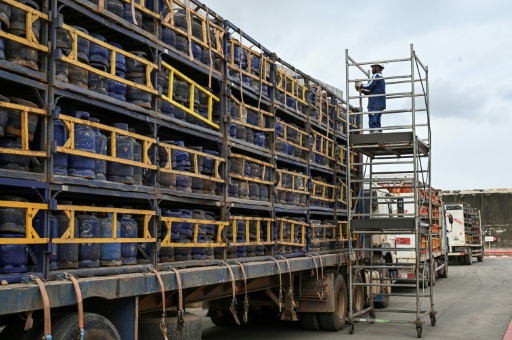 Des ouvriers chargent des bouteilles de gaz sur des camions avant leur expédition depuis le site de Petro Ivoire, situé dans la zone industrielle de Vridi, à Abidjan, capitale économique de la Côte d'Ivoire, le 7 juillet 2026 — Issouf SANOGO / AFP