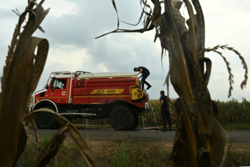 Des pompiers s'apprêtent à remplir leur citerne d'eau, le 16 août 2026 à Luglon, dans les Landes — Gaizka IROZ / AFP