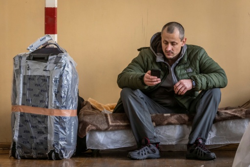 Un homme est assis dans un centre d'accueil temporaire pour réfugiés ukrainiens installé dans une école primaire de Przemysl, dans l'est de la Pologne, le 26 février 2022, au lendemain de l'invasion russe de l'Ukraine