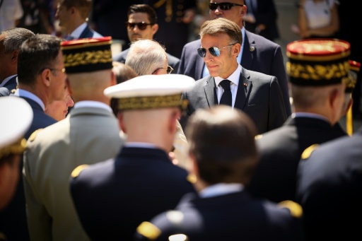 FLe président Emmanuel Macron (c) salue des officiers supérieurs à l'issue du traditionnel discours aux armées à l'hôtel de Brienne, à Paris, le 13 juillet 2026, à la veille du défilé annuel du 14 Juillet