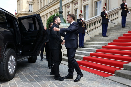 Le président Emmanuel Macron accueille le président ukrainien Volodymyr Zelensky (g) à l'Hôtel des Invalides avant un sommet de la "coalition des volontaires" pour le soutien à l'Ukraine, le 13 juillet 2026 à Paris