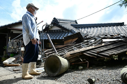 Un homme regarde sa maison effondrée à Hikawa, dans la préfecture de Kumamoto, le 30 juillet 2026, après le séisme qui a frappé le sud-ouest du Japon le 28 juillet — JIJI PRESS / AFP