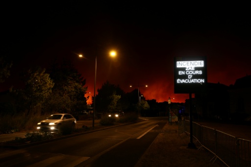 A sign near Le Porge reading 'Fire. Evacuation of the economic activity zone underway' — ROMAIN PERROCHEAU / AFP