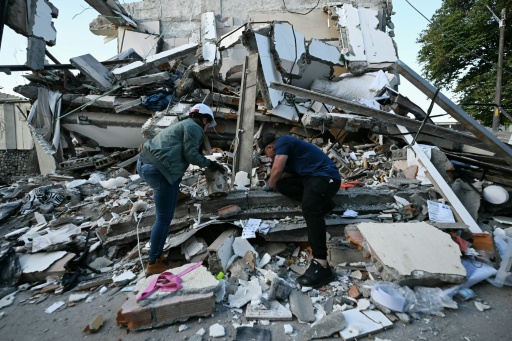 Duas pessoas retiram escombros de uma casa destruída pelo terremoto em Pereira, na Colômbia, em 11 de agosto de 2026 — Luis Acosta / AFP