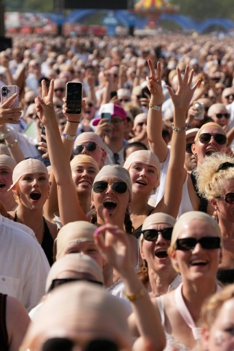 Des fans du rappeur américain Pitbull portent de faux crânes chauves avant un concert de l'artiste, le 10 juillet 2026 à Londres