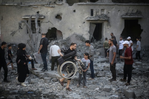 Des Palestiniens inspectent un immeuble détruit par une frappe israélienne à Deir al-Balah, dans le centre de la bande de Gaza, le 29 juillet 2026 — Eyad Baba / AFP