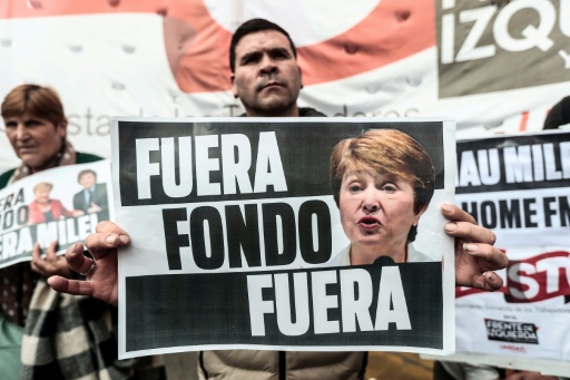 Ativista exibe cartaz com a inscrição 'Fora, Fundo', durante um protesto contra a visita da diretora-gerente do FMI, Kristalina Georgieva, na Praça de Maio, em Buenos Aires, em 27 de julho 2026 — Nicolas SUAREZ / AFP