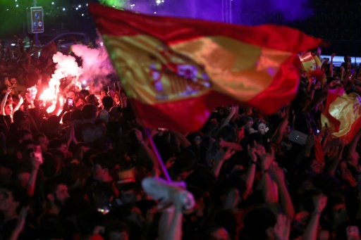 Les supporters espagnols, rassemblés sur la place Colon de Madrid le 19 juillet 2026 craquent des fumigènes et agitent des drapeaux de l'Espagne après le sacre de la Roja au Mondial — Pierre-Philippe MARCOU / AFP
