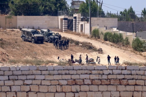 Des soldats israéliens au dessus de colons à Qusra, au sud de Naplouse en Cisjordanie occupée, le 12 août 2026 — Zain JAAFAR / AFP