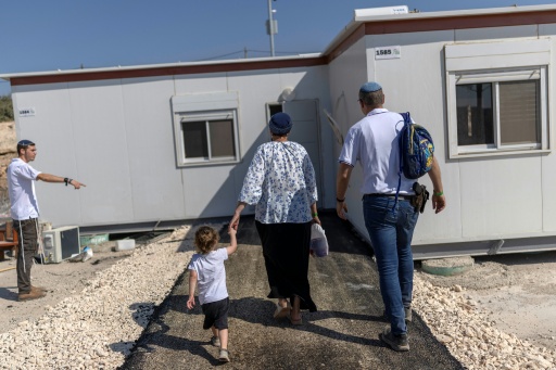 Des colons israéliens devant une maison après la réouverture d'une colonie à Ganim, en Cisjordanie occupée, le 13 août 2026 — ilia YEFIMOVICH / AFP