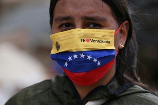 Una voluntaria con una mascarilla con los colores de la bandera de Venezuela reparte comida a los rescatistas en Caraballeda, estado La Guaira, el 11 de julio de 2026, tras los terremotos que sacudieron la región