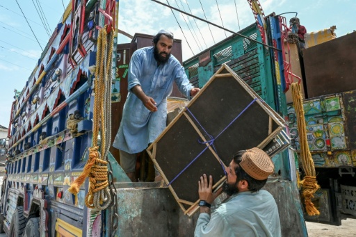 Des réfugiés afghans chargent leurs affaires dans un camion à Peshawar, le 13 juillet 2026 au Pakistan, alors qu'ils s'apprêtent à retourner en Afghanistan — Abdul MAJEED / AFP