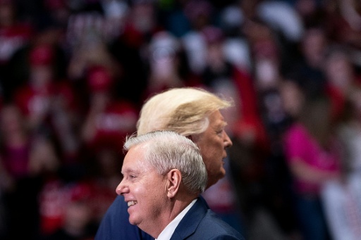 Senator Lindsey Graham (R-SC) arrives to speak with US President Donald Trump (R) during a rally at Bojangles' Coliseum in  2020