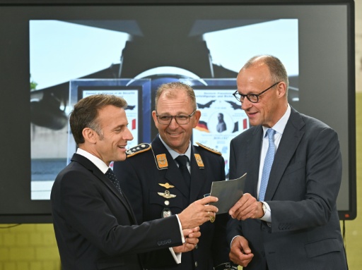 Le chancelier allemand Friedrich Merz (d) et le président français Emmanuel Macron écoutent les explications du commandant de l'escadre aérienne tactique 31 "Boelcke", le colonel Rene Diegeler, à leur arrivée à la base aérienne de Nörvenich, dans l'ouest de l'Allemagne, le 17 juillet 2026 — INA FASSBENDER / AFP