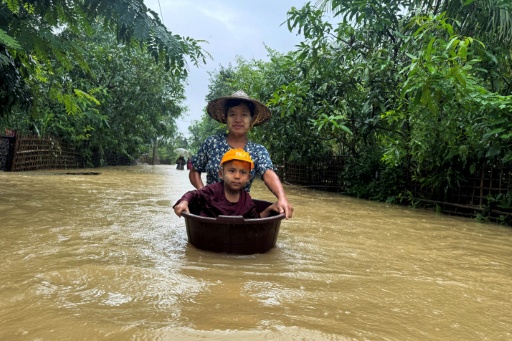 Un enfant dans un seau poussé sur l'eau après des inondations causées par des pluies diluviennes à Kyauktaw, dans l'Etat de Rakhine, dans l'ouest de la Birmanie